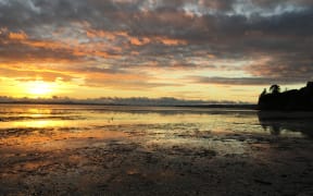 Eastern Beach in Auckland at sunrise with the tide out.