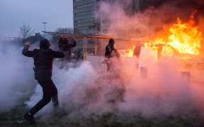 A car is ablaze in the Paris suburb of Bobigny during a protest against police brutality sparked by the arrest of a young man called Theo.