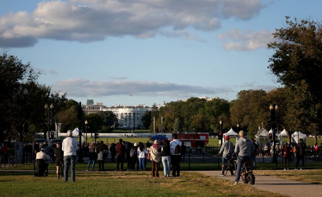 WASHINGTON, DC - OCTOBER 02: Bystanders look on as Marine One, the presidential helicopter, waits on the south lawn at the White House to carry U.S. President Donald Trump to Walter Reed National Military Medical Center October 2, 2020 in Washington, DC.