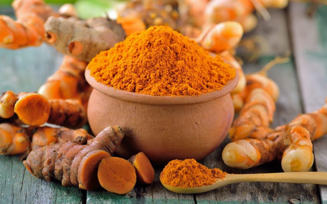 turmeric roots in the basket on wooden table