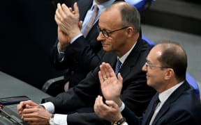 Designated German Chancellor Friedrich Merz (C) is applauded after he was elected in a second round of voting during a session at the Bundestag (lower house of parliament), in Berlin on 6 May, 2025.