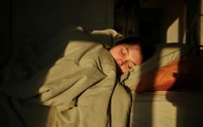 Person sleeping under a duvet.