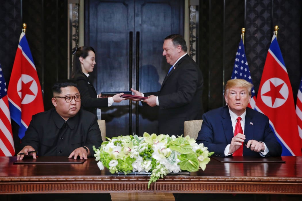 US President Donald Trump and North Korea's leader Kim Jong Un participate in a signing ceremony as part of the US-North Korea summit, at the Capella Hotel on Sentosa Island in Singapore on June 12, 2018.