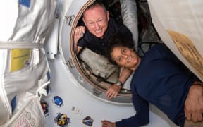 In this photo from NASA, astronauts Butch Wilmore and Suni Williams appear inside the vestibule between the forward port on the International Space Station's Harmony module and Boeing's Starliner spacecraft in June.