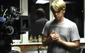 Gerard Johnstone stands near a film camera