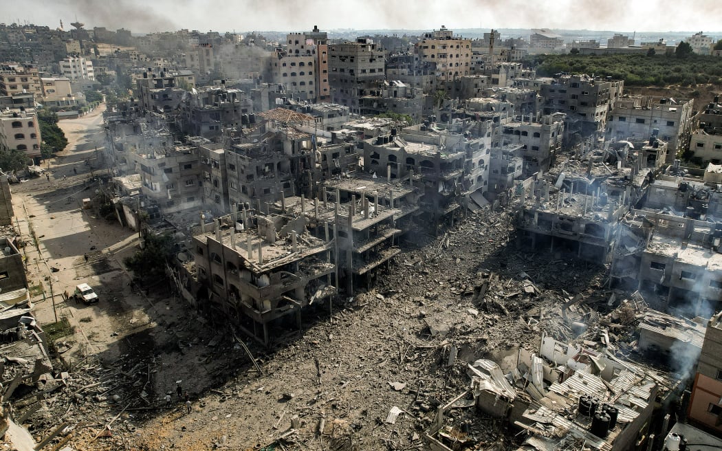 This picture taken on October 11, 2023 shows an aerial view of buildings destroyed by Israeli air strikes in the Jabalia camp for Palestinian refugees in Gaza City. Israel declared war on Hamas on October 8 following a shock land, air and sea assault by the Gaza-based Islamists. The death toll from the shock cross-border assault by Hamas militants rose to 1,200, making it the deadliest attack in the country's 75-year history, while Gaza officials reported more than 900 people killed as Israel pounded the territory with air strikes. (Photo by Yahya HASSOUNA / AFP)