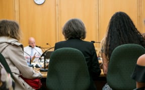 Maggie Wilkinson (centre) gives her submission to Parliament on her petition calling for an inquiry into forced adoption in New Zealand between the 1950s and 1980s with her daughters either side.