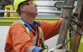 Linesman Andrew Henare works to check homes on Anzac Parade in Whanganui.