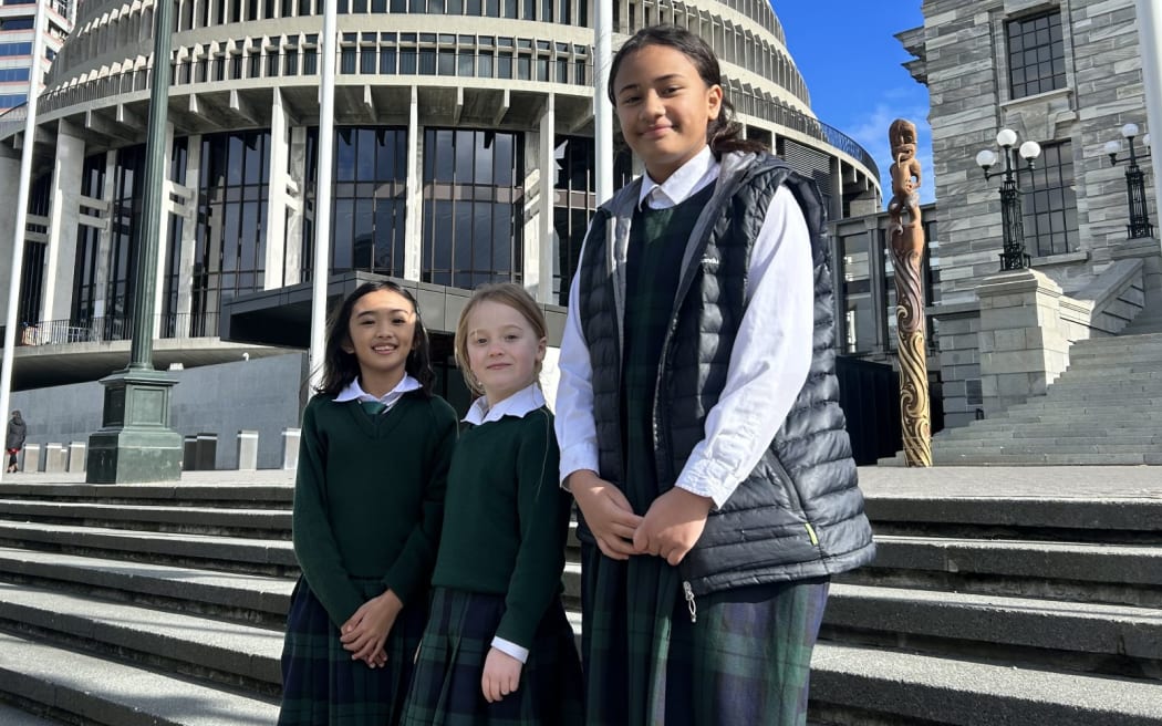 Athena Bacero, Sophie Wheddon and Tala Alofa pictured on the steps at Parliament, delivering a message to politicians about their concerns regarding climate change.