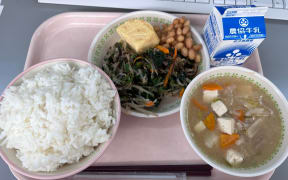 A meal from Kyuushoku (the Japanese school lunch programme), featuring tofu miso soup, rice, vegetables and nato beans.