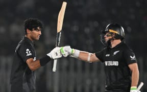 New Zealand’s Rachin Ravindra celebrates after scoring a century with teammate Tom Latham during the ICC Champions Trophy match against Bangladesh, 2025.