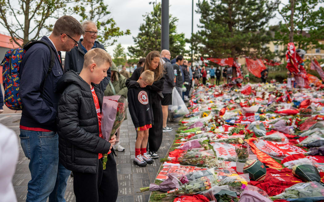 Well-wishers leave flowers, scarves and shirts at a memorial set up close to Anfield football ground for their Portuguese forward Diogo Jota in Liverpool, north-west England July 4, 2025. Liverpool striker Diogo Jota died along with his brother early July 3, 2025 in a road accident in northwest Spain, the Spanish Civil Guard said. The accident occurred on a highway in the province of Zamora. The vehicle "left the road" before bursting into flames, the Civil Guard said, adding that the two passengers, Diogo Jota and his brother Andre Felipe, also a professional footballer, were deceased. (Photo by Mark NAFTALIN / AFP)