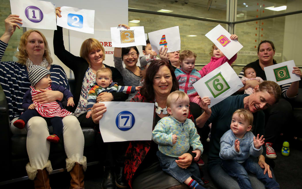Labour’s spokesperson for Women, Sue Moroney (holding number 7), and a group of mothers supporting thenew paid parental leave bill.