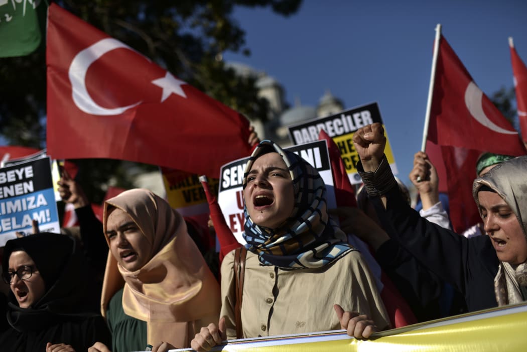 Pro-Erdogan protesters wave Turkish flags and shout slogans as they demonstrate in Istanbul in support the government on July 16, 2016, following a failed coup attempt.