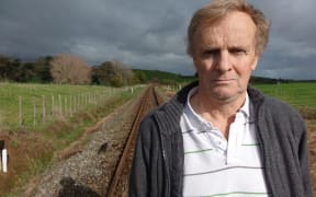 Bill Gribble in front of the level crossing near his land.