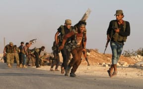 Fighters from the Free Syrian Army take part in a battle against the Islamic State (IS) group jihadists in the northern Syrian village of Yahmoul in the Marj Dabiq area north of the embattled city of Aleppo on October 10, 2016.