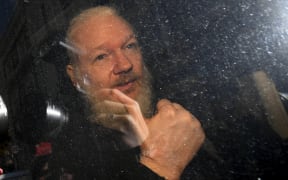 Julian Assange gestures as he arrives at Westminster Magistrates' Court in London, after the WikiLeaks founder was arrested by officers from the Metropolitan Police and taken into custody Thursday April 11, 2019.