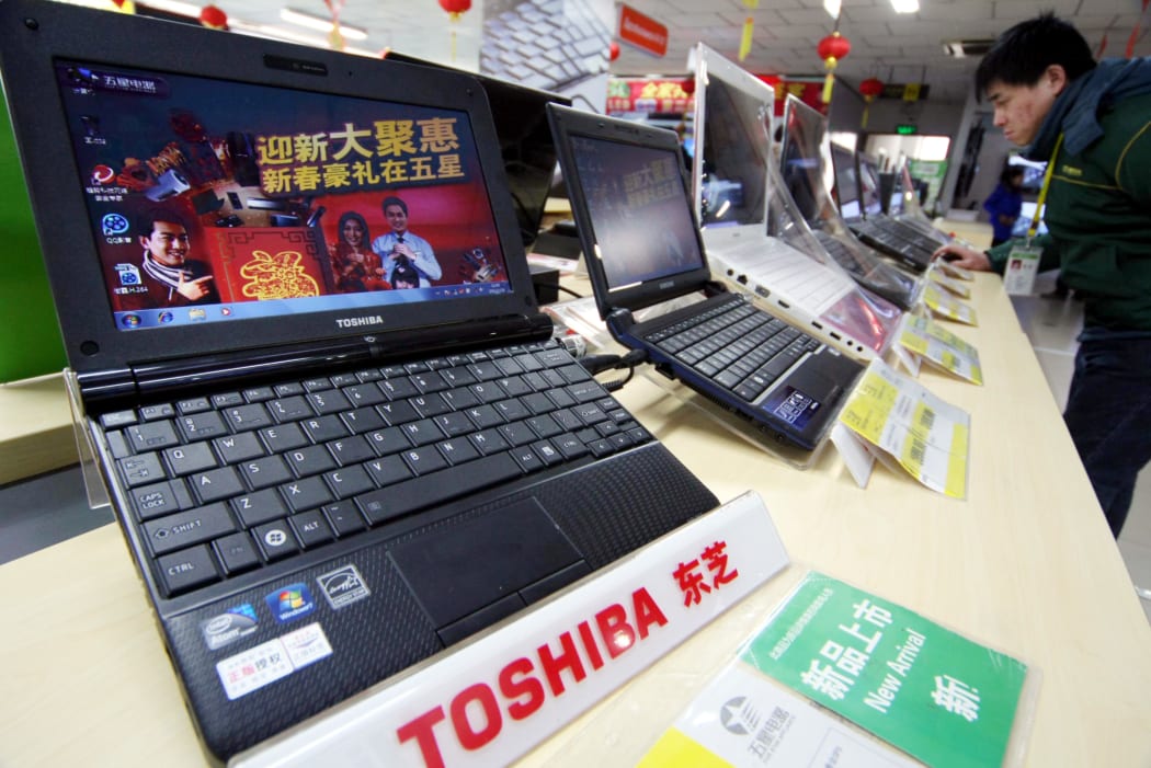 A customer shops for Toshiba laptop computers at a home appliance store in Nantong city, east China's Jiangsu province, 28 January 2011.