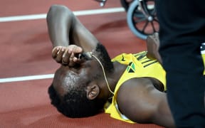 Usain Bolt lays on the track after pulling up injured in the final of the 4x100m relay.