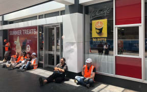 Construction workers wait for power to return outside the closed McDonald's cafe.