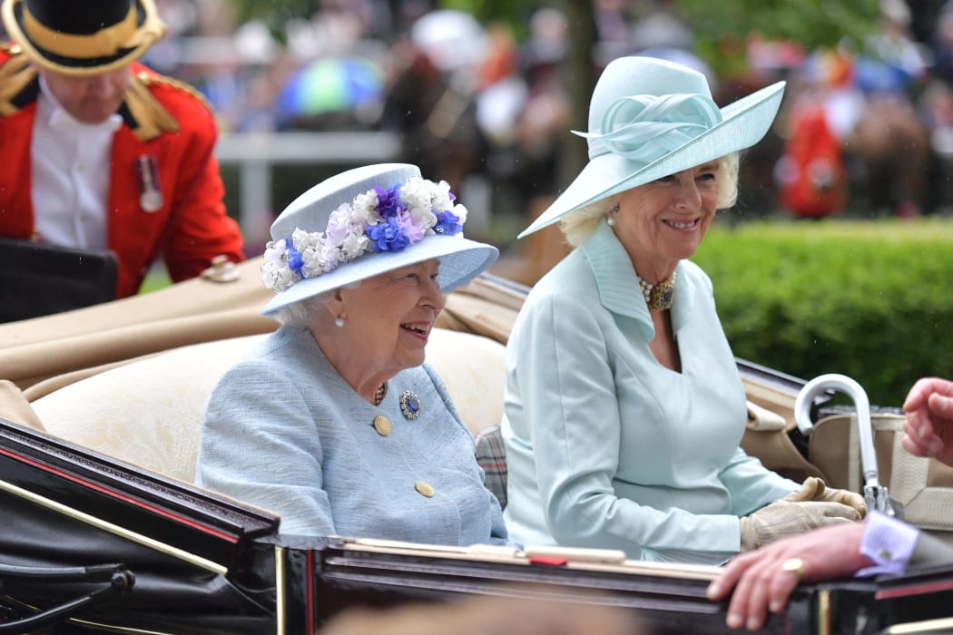 Britain's Queen Elizabeth II (C) and Britain's Camilla, Duchess of Cornwall (R) arrive by carriage on day two of the Royal Ascot horse racing meet, in Ascot, west of London, on June 19, 2019.