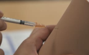 A needle is inserted into a 'simulation arm' in Covid-19 vaccine training.