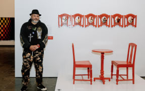 Winner of the National Contemporary Art Award 2023 Tawhai Rickard (Ngaati Uepohatu, Ngaati Porou) with his work titled ‘Scenes from a Victorian Restaurant’.