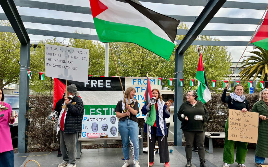 Council candidate Aimee Payne, centre left, with pro-Palestine protesters outside the ACT party public meeting.