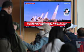 People watch a television screen showing a news broadcast with file footage of a North Korean missile test, at a railway station in Seoul on April 22, 2024. North Korea has fired an unidentified ballistic missile into the sea off South Korea's east coast, Seoul's military said on April 22, the latest in an apparent volley of tests by Pyongyang this year. (Photo by Jung Yeon-je / AFP)