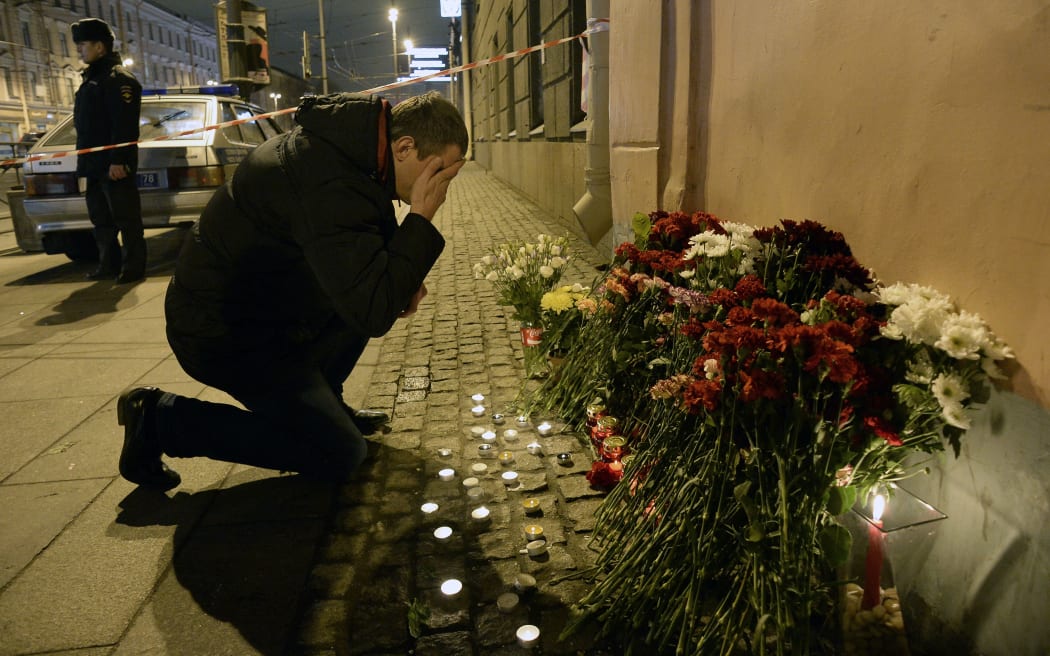 A places flowers in memory of victims of the blast in the Saint Petersburg metro outside Technological Institute station.