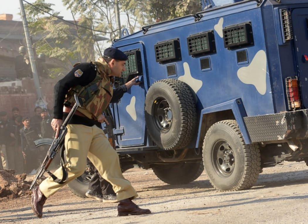 Pakistani security personnel take position outside the Agriculture Training Institute after an attack by Taliban militants.