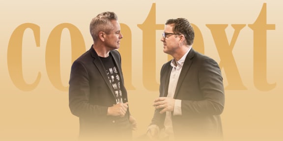 Two men converse intently way in front of large letters that read "Context"
