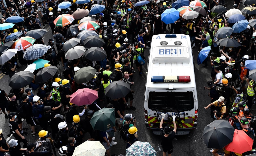 Protesters block a police van during a demonstration in the district of Yuen Long in Hong Kong on July 27, 2019. -