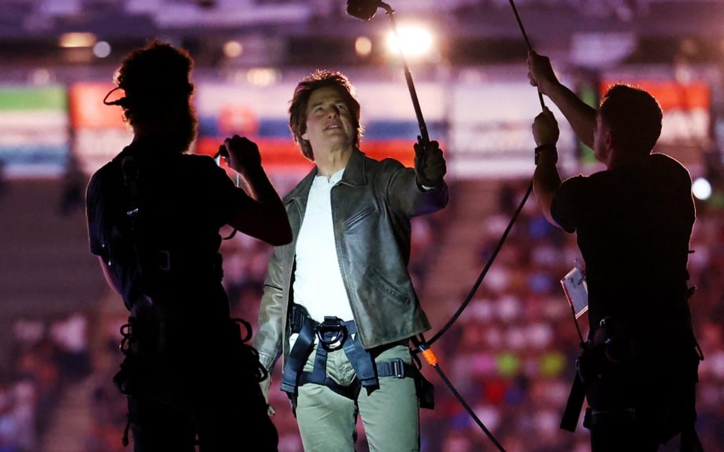 US actor Tom Cruise is pictured on the roof of the Stade de France during the closing ceremony of the Paris 2024 Olympic Games at the Stade de France, in Saint-Denis, in the outskirts of Paris, on August 11, 2024. (Photo by Fabrizio Bensch / POOL / AFP)