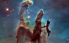 The Eagle Nebula’s Pillars of Creation - gas clouds and dust shaped by nearby stars.