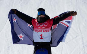 Gold medalist Zoi Sadowski Synnott  raises the New Zealand flag in the women's slopestyle snowboarding final during the Beijing 2022 Olympic Winter Games.