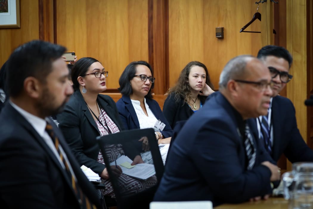 Journalist Esther Pavihi from Niue and journalist Tiana Haxton from the Cook Islands observe the Minister for Pacific Peoples at select committee in Wellington.