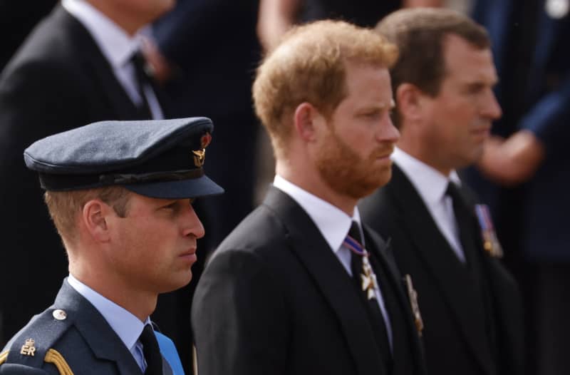 Britain's Prince William, Prince of Wales (L), Britain's Prince Harry, Duke of Sussex and Peter Phillips follow the coffin of Queen Elizabeth II, draped in the Royal Standard, on the State Gun Carriage of the Royal Navy, as it travels from Westminster Abbey to Wellington Arch in London on September 19, 2022, after the State Funeral Service of Britain's Queen Elizabeth II. Leaders from around the world attended the state funeral of Queen Elizabeth II. The country's longest-serving monarch, who died aged 96 after 70 years on the throne, was honoured with a state funeral on Monday morning at Westminster Abbey. (Photo by Odd ANDERSEN / POOL / AFP)