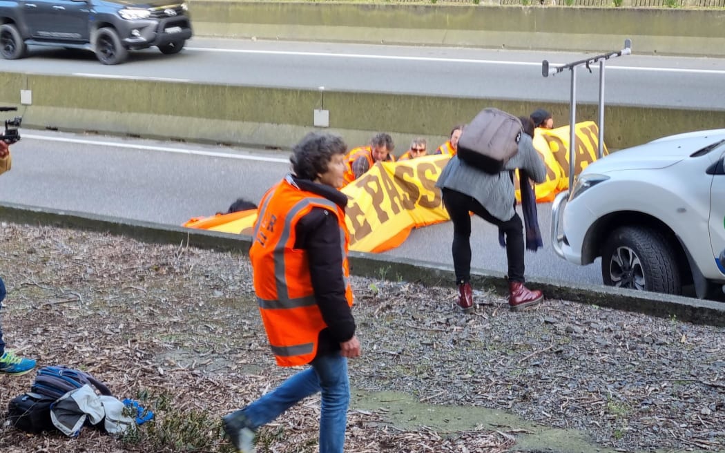 Protesters, believed to be climate activists, wearing high-viz vests are blocking the southbound lane of Wellington's Terrace Tunnel while police work to remove them.