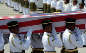 Soldiers carry a coffin with the remains of a Malaysian victim of the Malaysia Airlines flight MH17 crash during a ceremony at Kuala Lumpur International Airport.