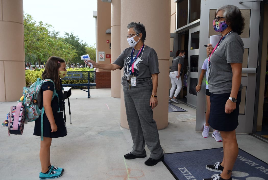 Staff checking the temperature of students in Orlando, Florida, last year. The upcoming reopening of schools is causing fierce debate.