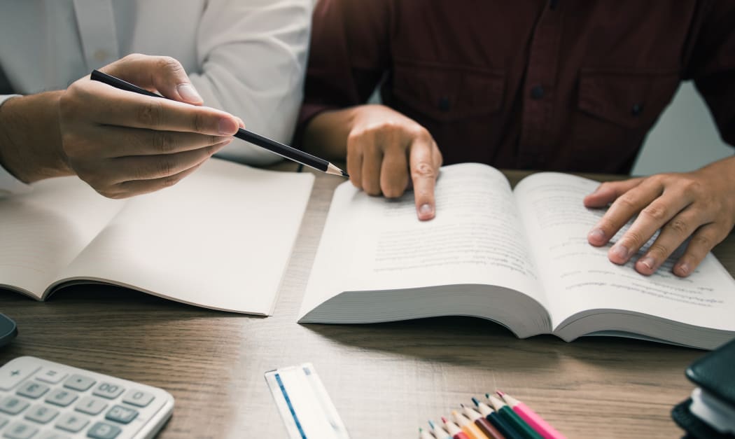 Teenager studying at desk and doing homeworks