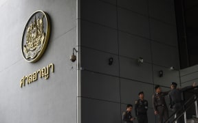 Thai policemen stand guard outside of a criminal court in Bangkok
