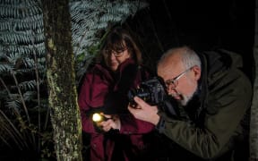 Gillian & Darryl Torckler doing photography in the bush at night.