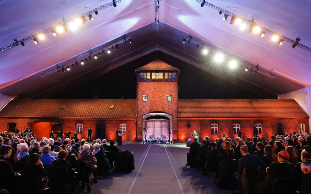 Polish historian and Holocaust survivor Marian Turski (R) delivers a speech in front of the main gate of the Auschwitz-Birkenau camp, the so-called Death Gate, during commemorations on the 80th anniversary of the liberation of the German Nazi concentration and extermination camp Auschwitz-Birkenau by the Red Army, in Oswiecim, Poland on January 27, 2025. The camp was set up by Nazi German occupiers in southern Poland in 1940 and liberated by Soviet troops on January 27, 1945 -- just months before the end of the Second World War. (Photo by Ludovic MARIN / POOL / AFP)