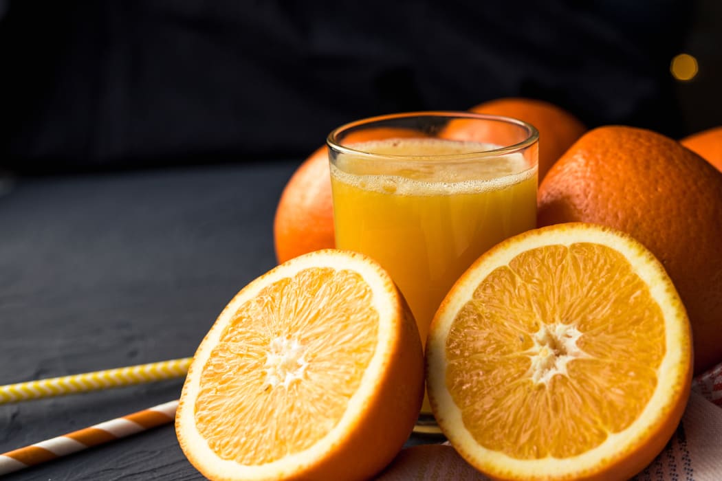 Fresh orange juice and fresh fruit oranges on a black background