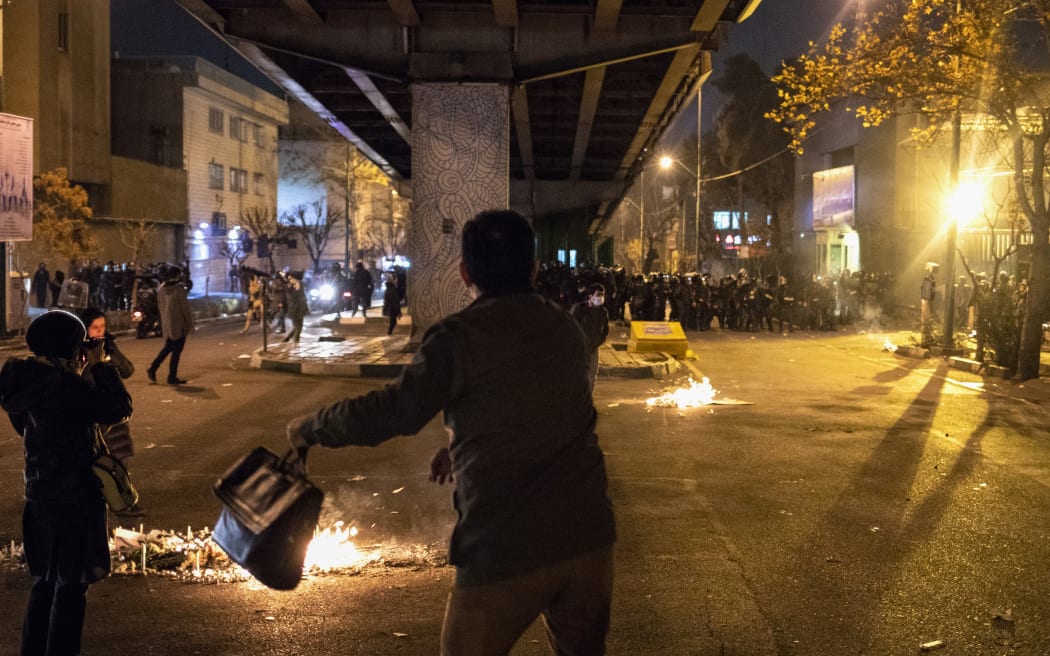 Iranian riot police stand guard as protesters gather in front of Tehran's Amir Kabir University on January 11, 2020.