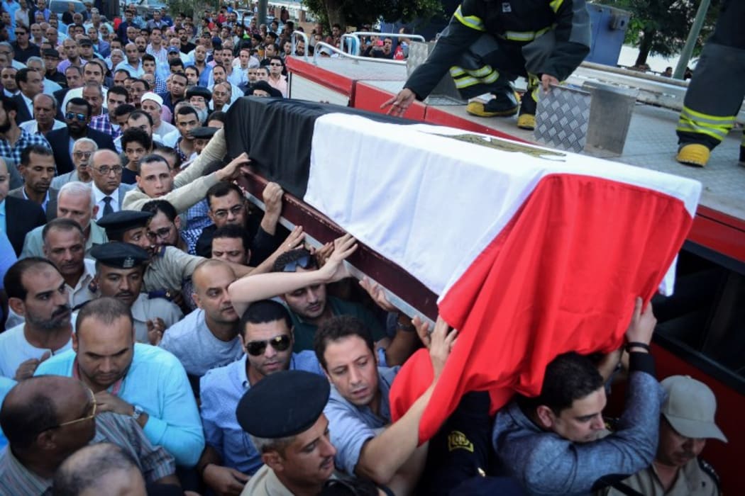 People carry the coffin of Egyptian police officer Mohamed Wahid, killed a day earlier in a shoot-out with suspected militants southwest of Cairo.