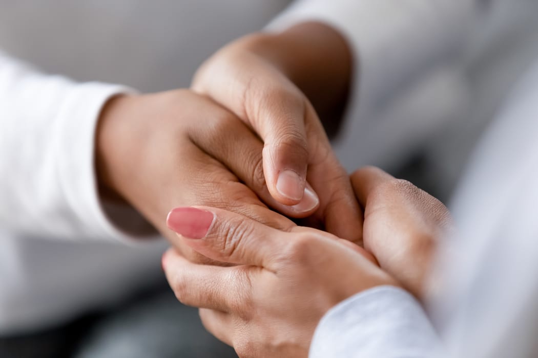 Close up caring African American mother holding child hands, showing love and support, black mum comforting, caressing kid, children protection concept, family enjoying moment together