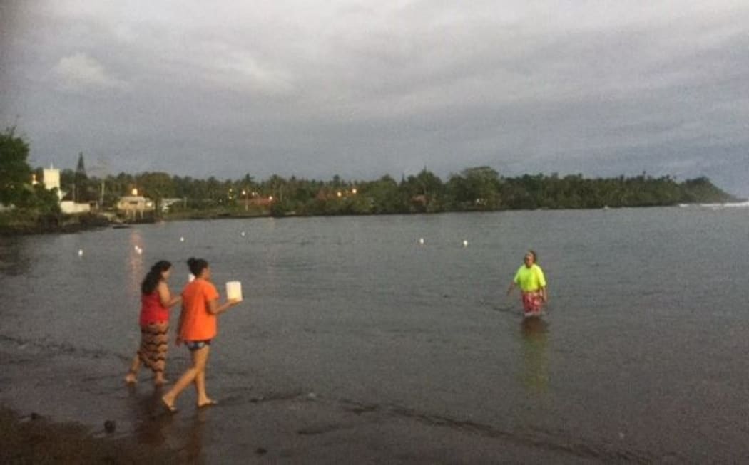 Floating candles are placed in the sea to remember those who died in the 2009 tsunami in Leone